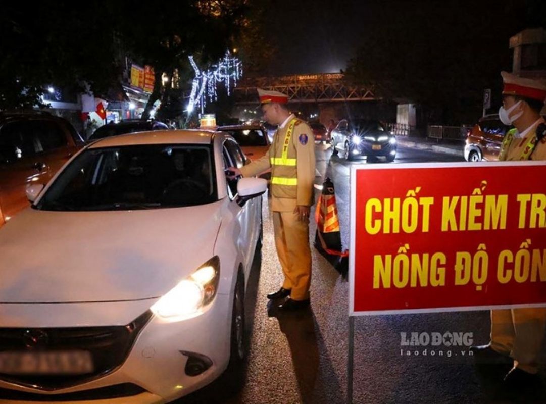 Cảnh sát giao thông đang sử dụng máy thổi kiểm tra nồng độ cồn của người điều khiển phương tiện